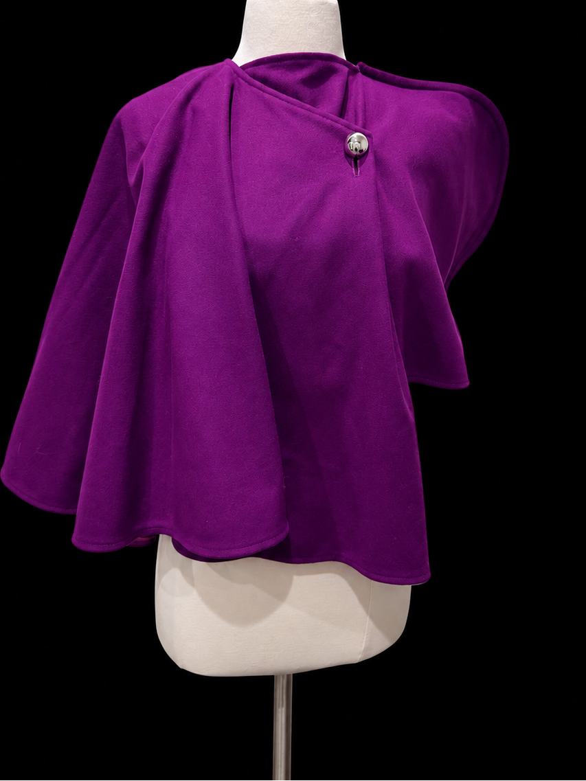A vibrant purple cape-style top with draped sleeves and a single decorative button at the neckline.