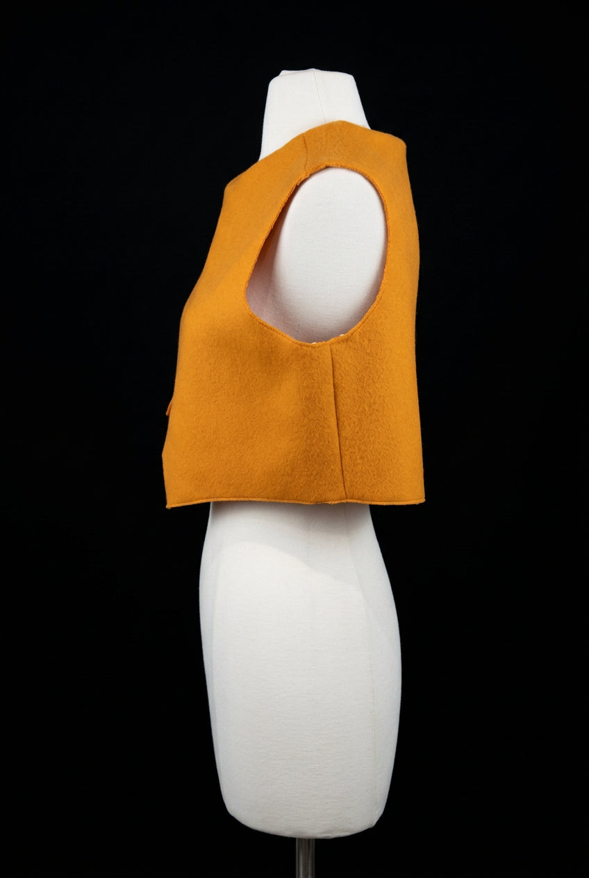 An orange sleeveless cropped vest with a large keyhole cutout, 
